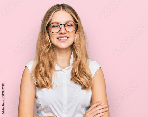 Beautiful young caucasian girl wearing casual clothes and glasses happy face smiling with crossed arms looking at the camera. positive person.