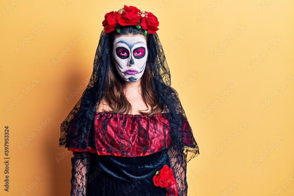 Young woman wearing day of the dead costume over yellow depressed and worry for distress, crying angry and afraid. sad expression.