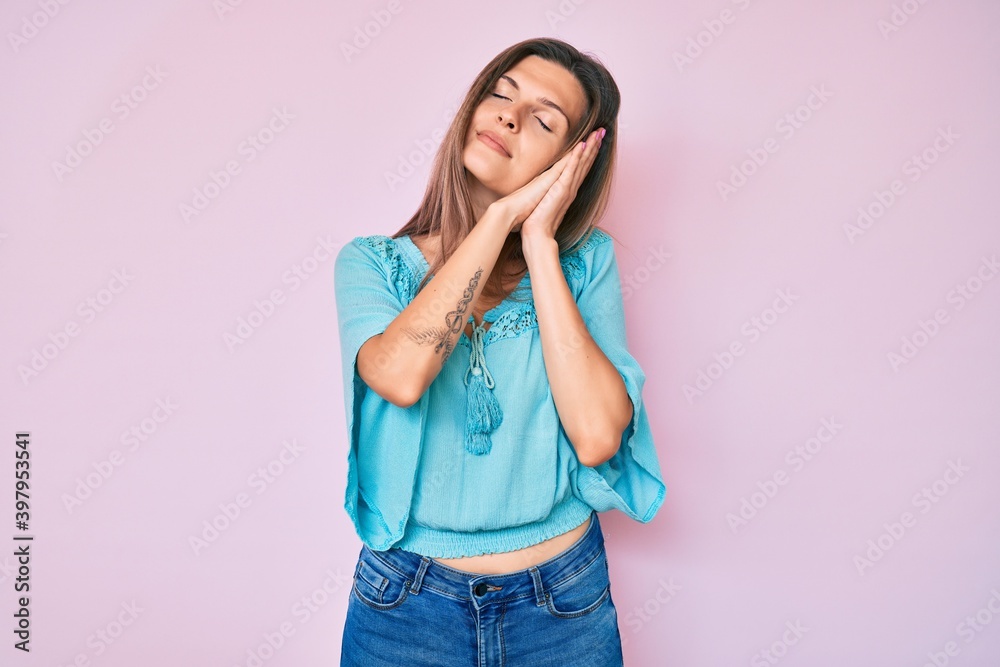 Beautiful caucasian woman wearing casual clothes sleeping tired dreaming and posing with hands together while smiling with closed eyes. Beautiful caucasian woman wearing casual clothes sleeping tired dreaming and posing with hands together while smiling with closed eyes.