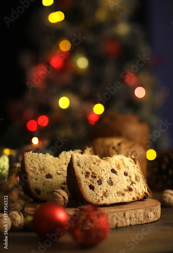 Delicious slice of Panettone with candied fruit on the table on a blurred background