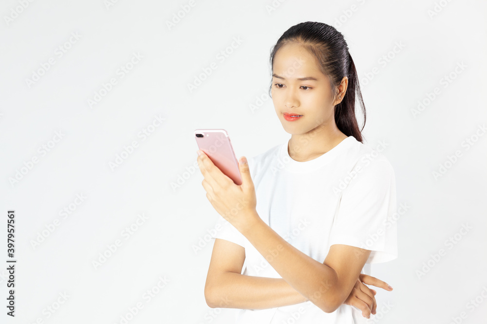 Portrait of a smiling young asia woman holding smartphone over white background Portrait of a smiling young asia woman holding smartphone over white background