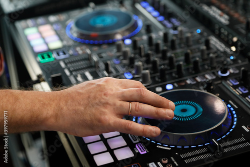 DJ playing music with sound mixer controller