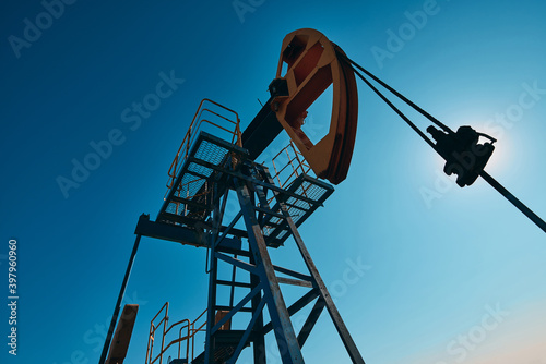 Oil pump are working in the blue sky background. 
World Oil Industry. Western region of Kazakhstan.
A oil pump is the overground drive for a reciprocating piston pump in an oil well.