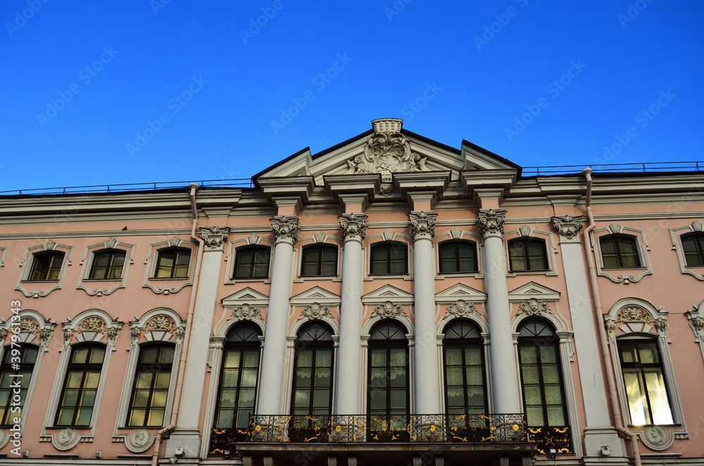 The facade of the house with columns against the blue sky in St. Petersburg. Architecture of St. Petersburg. Russia, St. Petersburg, 20.08.2020. High quality photo