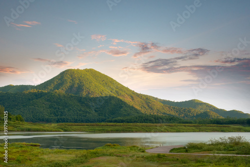 The beautiful sunshine in the morning with the reservoir of the mountain in front of the mountain and beautiful clouds in the sky.