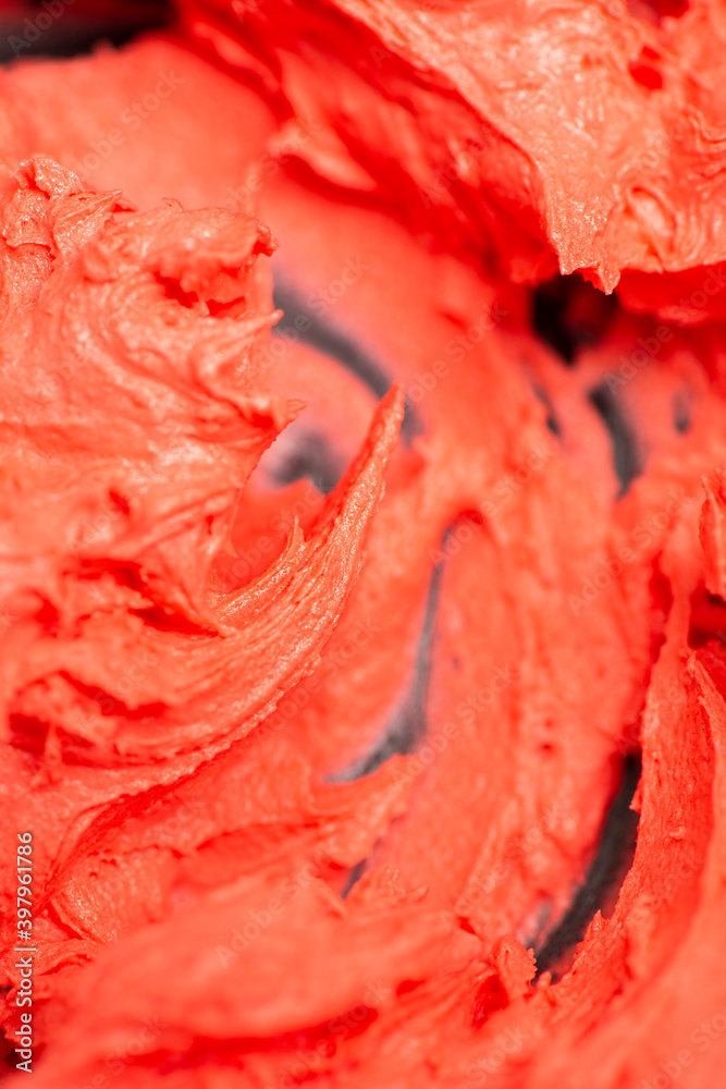 Detailed closeup of red buttercream icing being mixed.