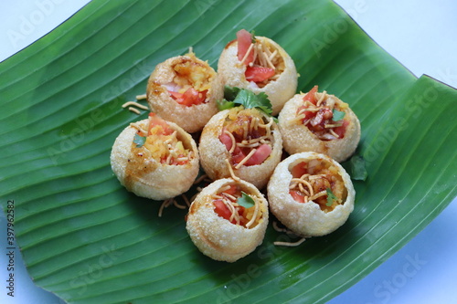 Shev Batata Puri chat, Aloo puri chaat, Indian popular street food, appetizer or snack, served on banana leaf photo