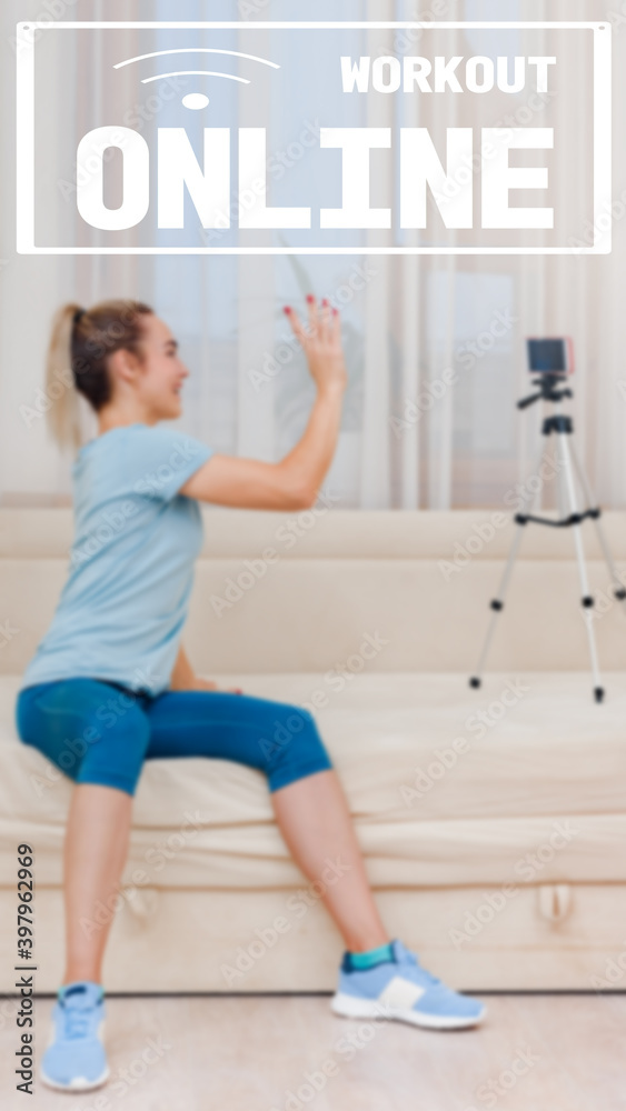 Naklejka premium image with text workout online and oriented for use on a smartphone. Happy young fitness instructor talking with clients through video call, Communication through instant messengers,