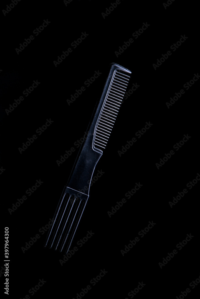 black plastic hair comb with reflection on black background black plastic hair comb with reflection on black background