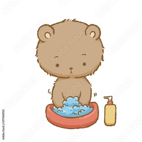 The bear was washing his hands in a small basin next to a bottle of liquid soap.