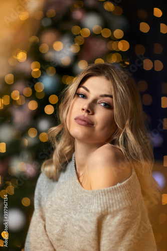 portrait of beautiful young woman with long curly hair on a background with bokeh. Christmas and New Year magic