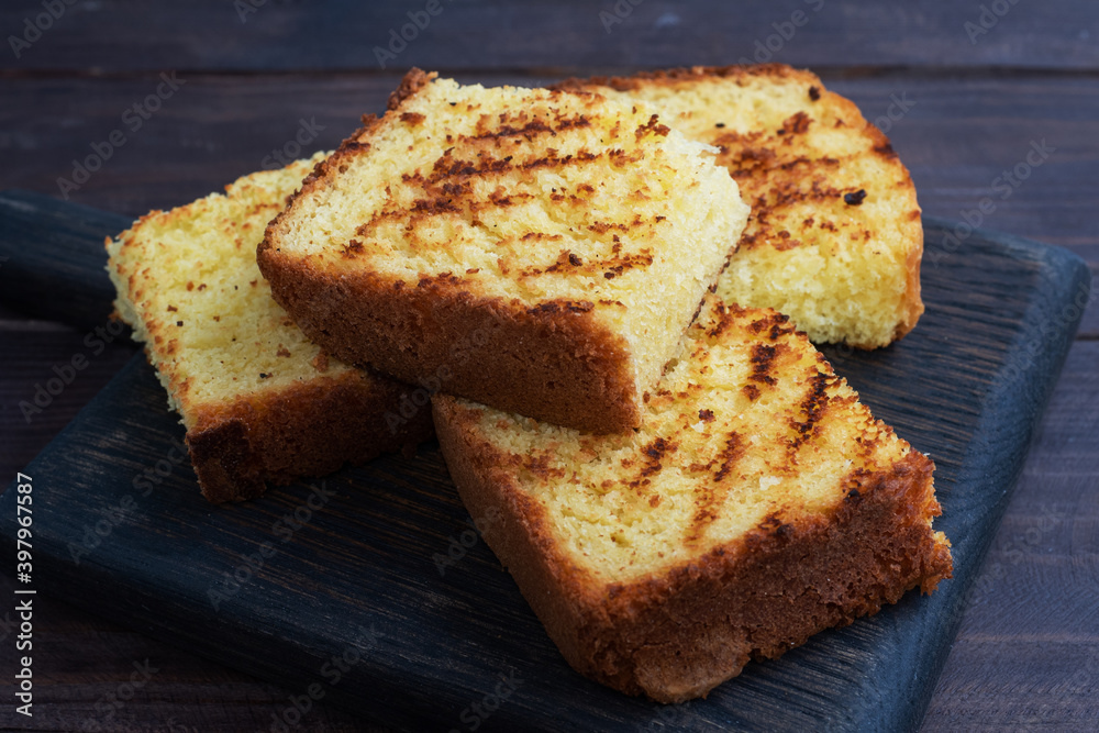 Slices toast wheat bread on a dark wooden background. Close up. Slices toast wheat bread on a dark wooden background. Close up.