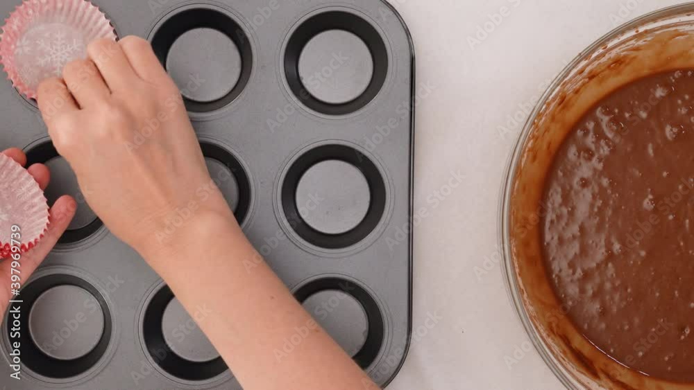 Chocolate cupcakes or chocolate muffins recipe. Paper liners close up on baking pan, flat lay Chocolate cupcakes or chocolate muffins recipe. Paper liners close up on baking pan, flat lay