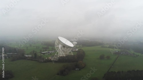 Aerial Jodrell bank observatory Lovell telescope misty rural countryside pull away tilt up photo