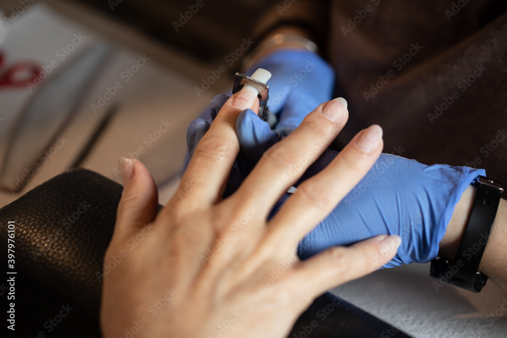 Closeup shot of a woman in a nail salon receiving a manicure - obrazy, fototapety, plakaty 