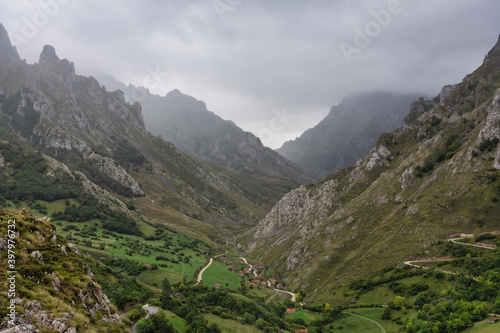 landscape of a mountainous valley with fog and dramatic sky, gray sky