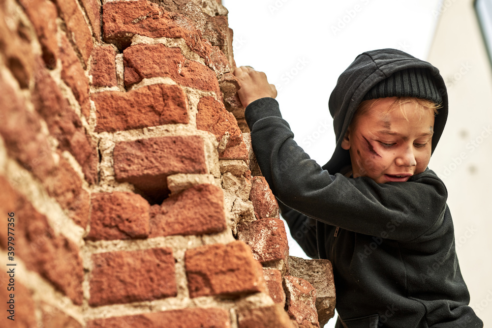 street child boy is climbing the building on streets, runs away from bandits. social issues concept