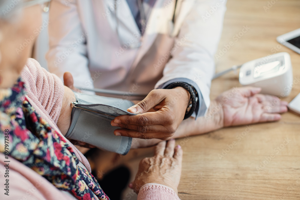 Φωτογραφία Close-up of a doctor measuring senior woman's blood pressure.