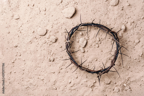 Crown of thorns over ground background. Top view. Copy space. Christian Easter concept. Crucifixion of Jesus Christ. He risen and alive. Jesus is the reason. Gospel, salvation photo