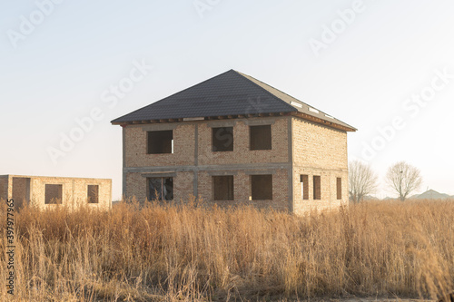 unfinished two-story brick house in nature