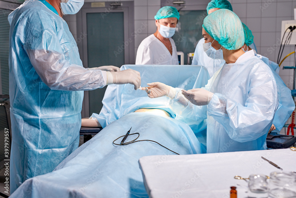 team of professional smart serious surgeons wearing medical uniform had difficult operation, in Technologically Advanced Hospital. operation on stomach, belly team of professional smart serious surgeons wearing medical uniform had difficult operation, in Technologically Advanced Hospital. operation on stomach, belly