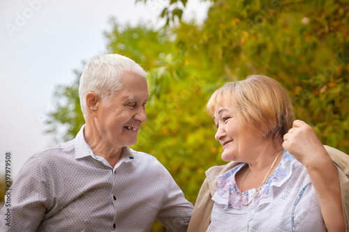 Elderly couple walking in the park on an autumn day.