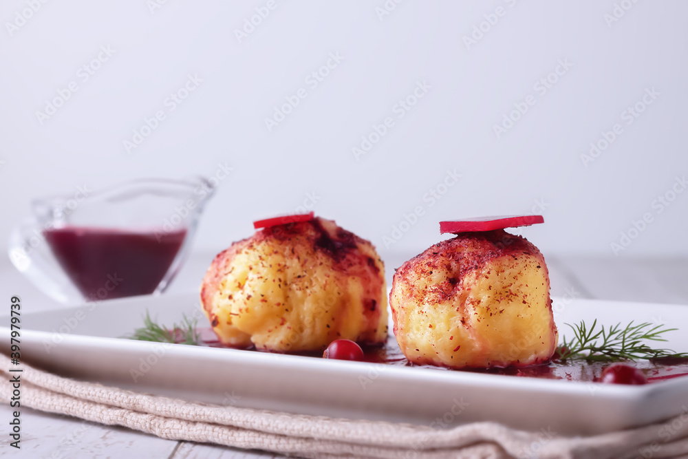 Swedish potato dumplings with cranberry sauce on a light background Swedish potato dumplings with cranberry sauce on a light background