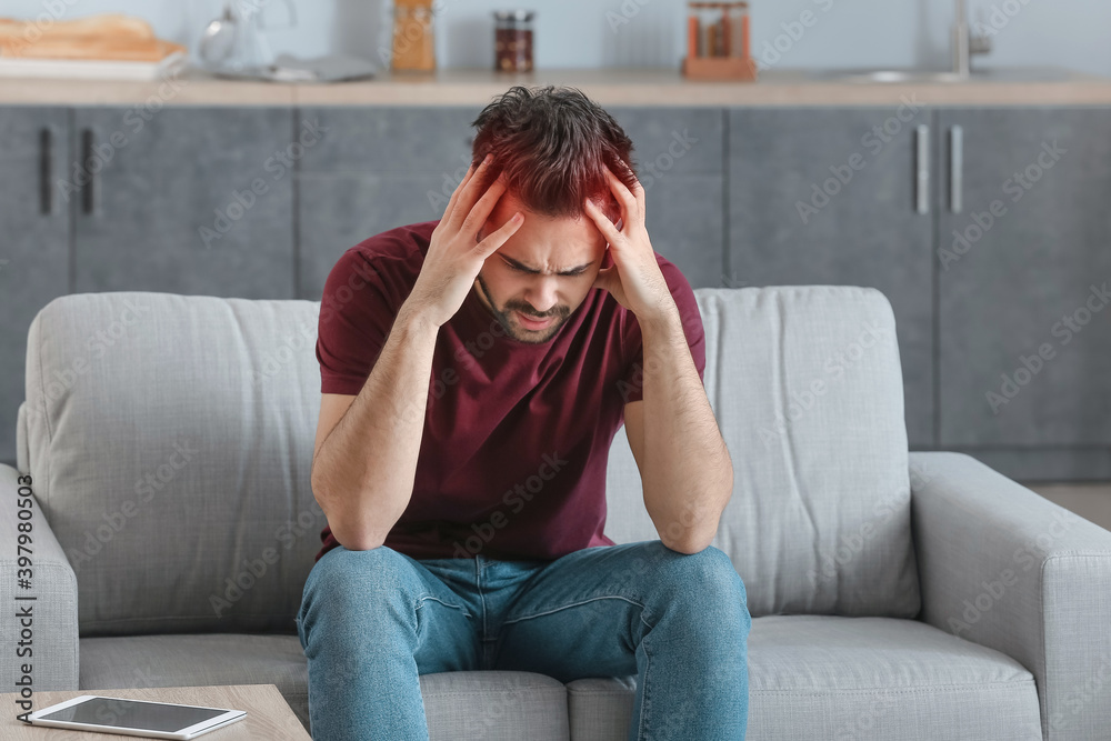 Young man suffering from headache at home Young man suffering from headache at home