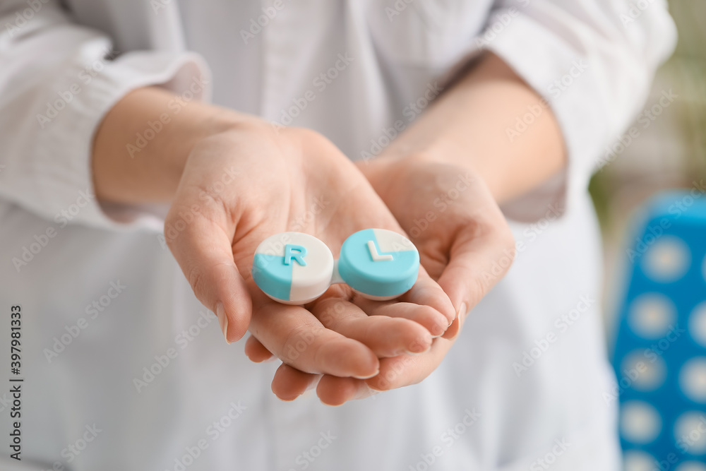 Woman holding contact lens case in clinic Woman holding contact lens case in clinic