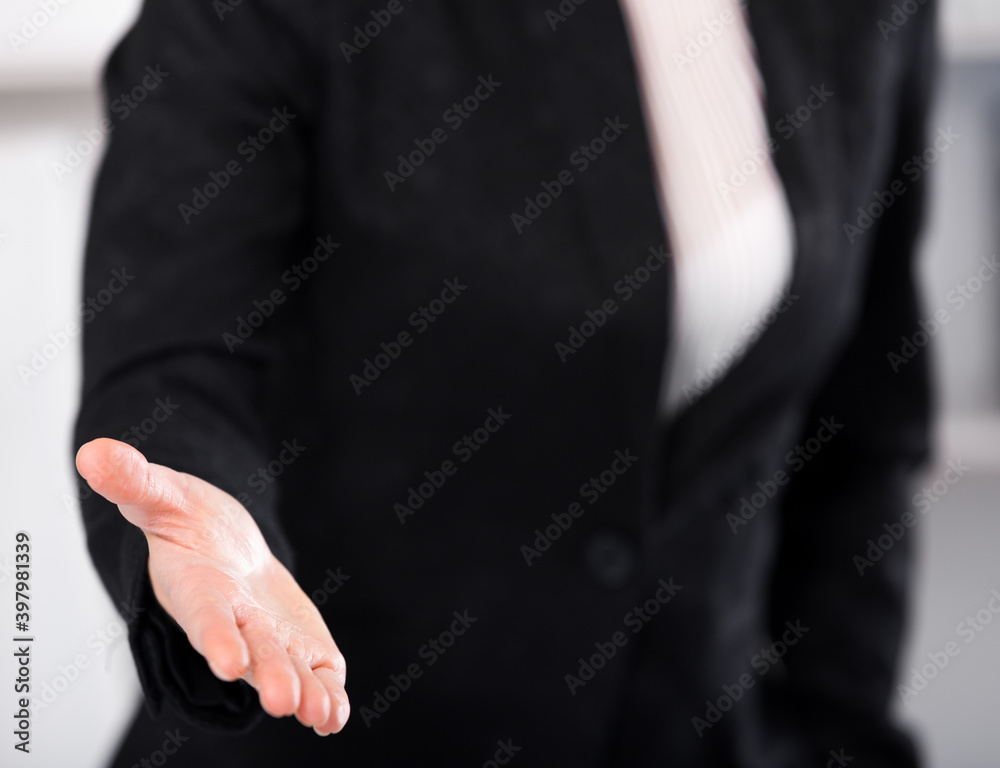 Obraz premium Woman office worker in black suit offering one's hand