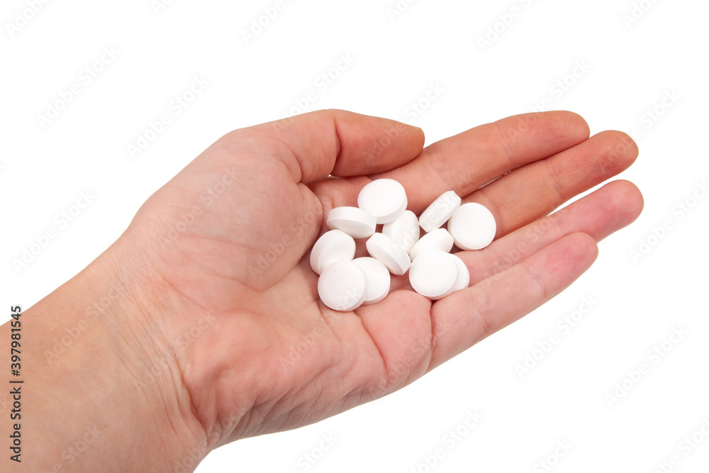 White pills for health care in hand isolated on the white White pills for health care in hand isolated on the white