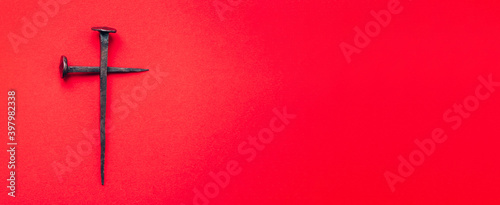 фотографія Cross made with rusty nails and drops of blood on red background