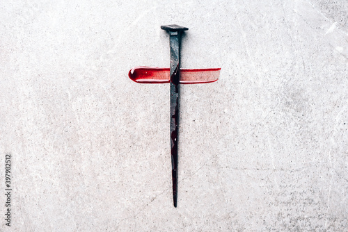 Photo Christian cross made with rusty nails, drops of blood on grey background