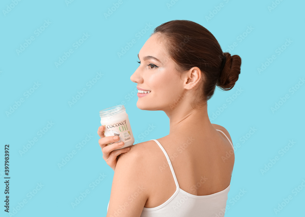 Beautiful young woman with coconut oil on color background Beautiful young woman with coconut oil on color background