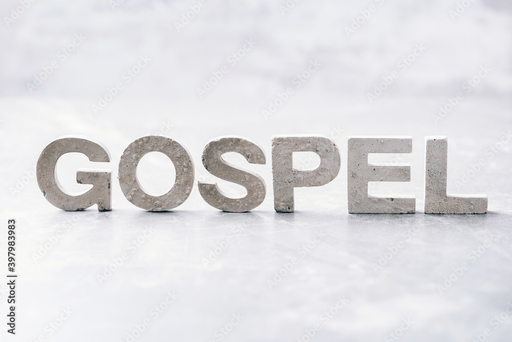 Word GOSPEL made with cement letters on grey marble background. Copy space. Biblical, spiritual or christian reminder. Christian music concert, Sunday service Word GOSPEL made with cement letters on grey marble background. Copy space. Biblical, spiritual or christian reminder. Christian music concert, Sunday service