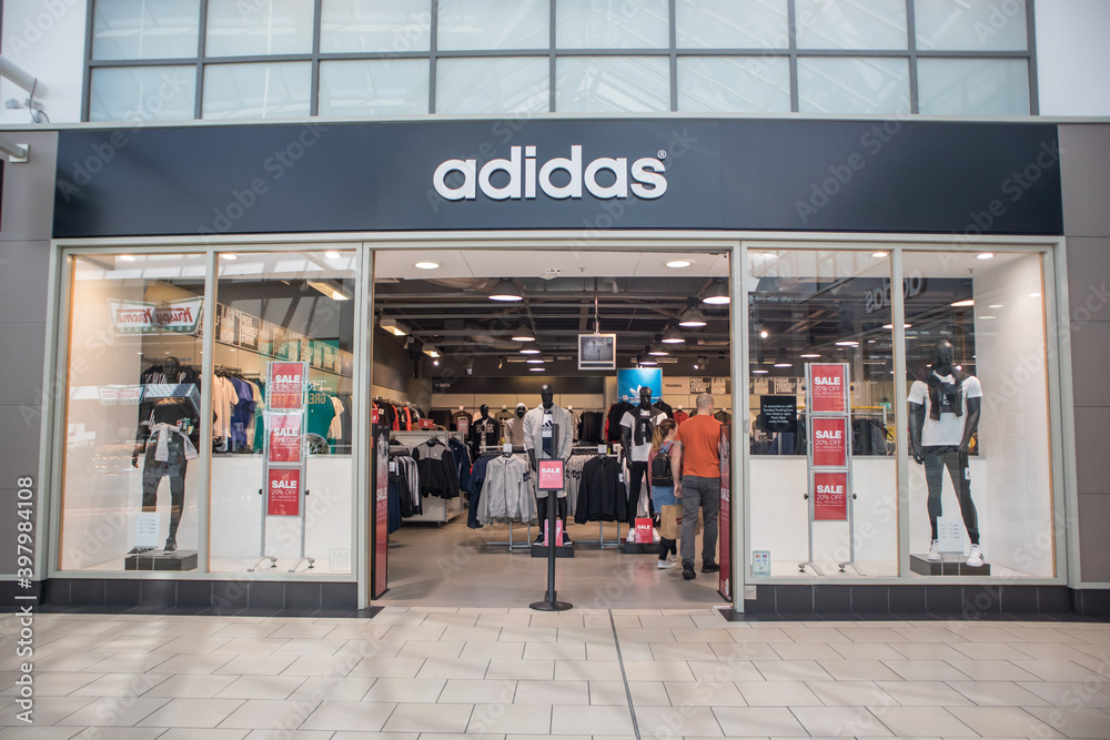 Exterior of Adidas sports leisure clothing store shop showing company logo, sign, signage and branding. Inside shopping mall Photos | Adobe Stock