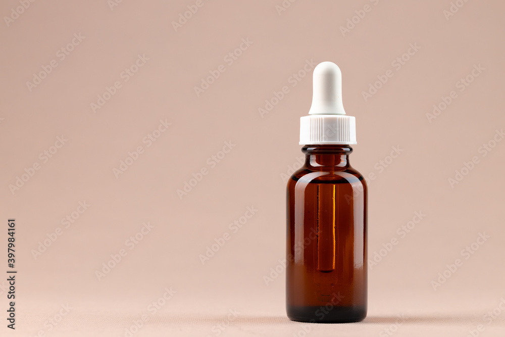 Beauty oil bottle with pipette on beige background Beauty oil bottle with pipette on beige background