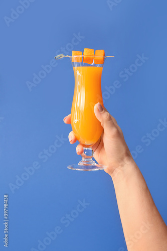 Fototapeta Naklejka Na Ścianę i Meble -  Female hand with glass of tasty pumpkin pie martini on color background