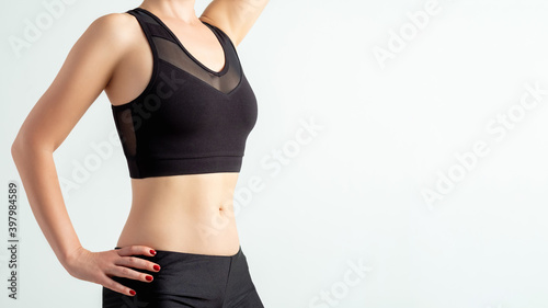 Woman sportswear. Outfit showcase. Workout clothing. Unrecognizable female athlete slim body in blank label black mesh crop top isolated on white copy space advertising background.