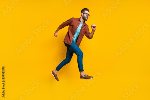 Full length body size photo of man running fast on sale jumping isolated on vivid yellow color background