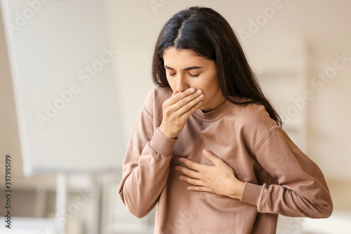 Tableau sur toile Coughing young woman at home