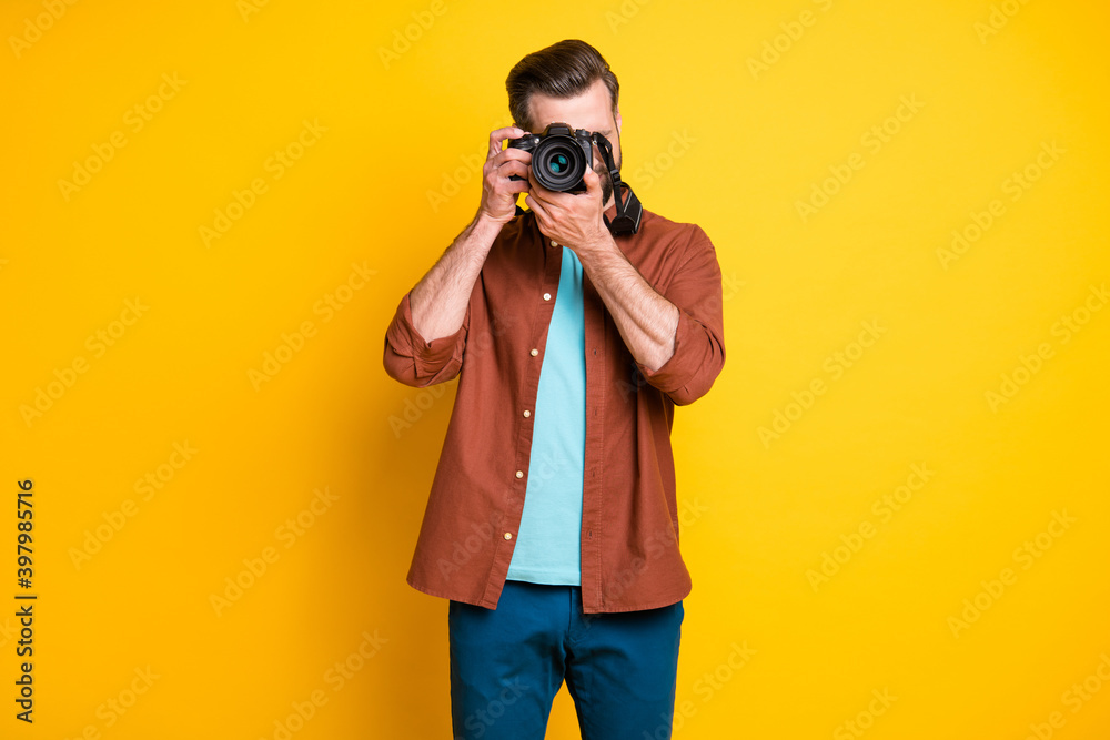 Photo portrait of bearded journalist taking photo with professional camera isolated on vibrant yellow color background Photo portrait of bearded journalist taking photo with professional camera isolated on vibrant yellow color background