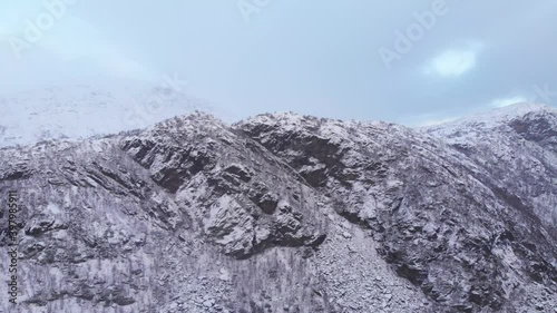 Long Rocky snowed ridge in the Scandinavian Mountain range - Fast aerial wide shot photo