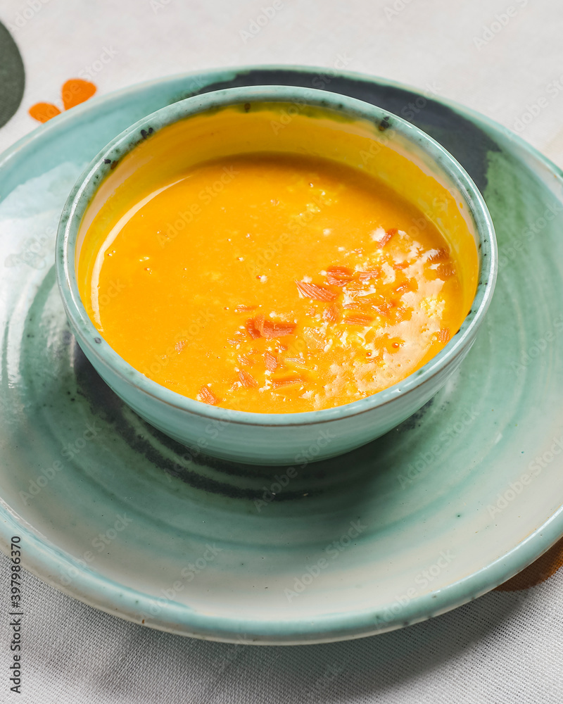 Pumpkin soup with fresh pumpkin seeds served in a bowl over traditional Ukrainian tablecloth. Ukrainian cuisine concept. Pumpkin soup with fresh pumpkin seeds served in a bowl over traditional Ukrainian tablecloth. Ukrainian cuisine concept.