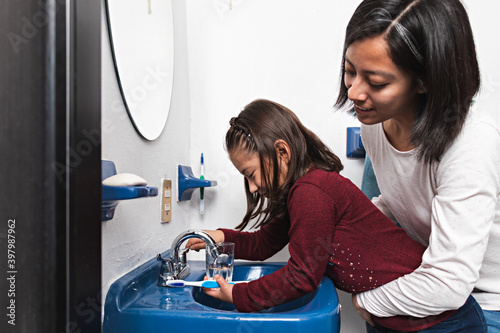 A girl filling a glass with water