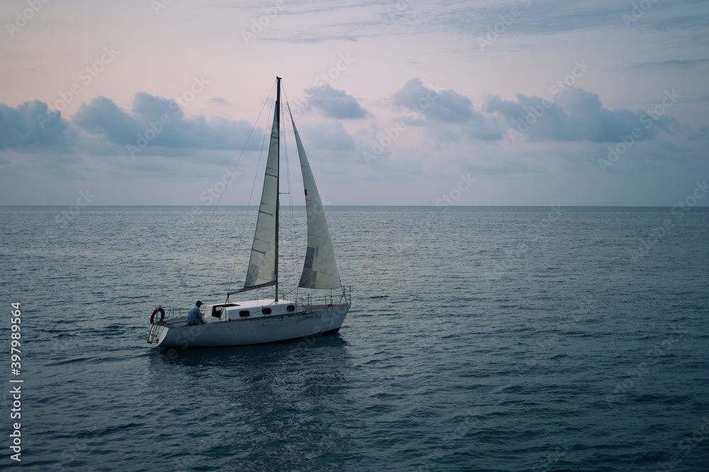 Sailing boat in the sea at sunset