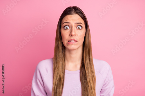Close-up portrait of lovely confused scared straight-haired girl biting lips panic isolated over pink pastel color background