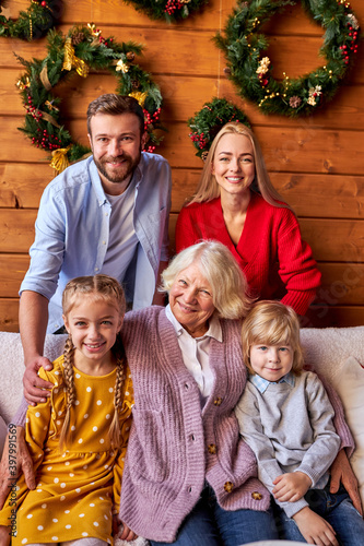 happy multi-generation familysitting on sofa looking at camera in living room, wearing casual wear, xmas celebration, family, relatives, new year concept