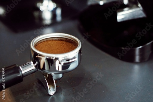 Close up preparing ground powder coffee in portafilter to make coffee.
