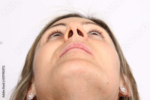 Portrait of a young woman face looking up, chin view from below
